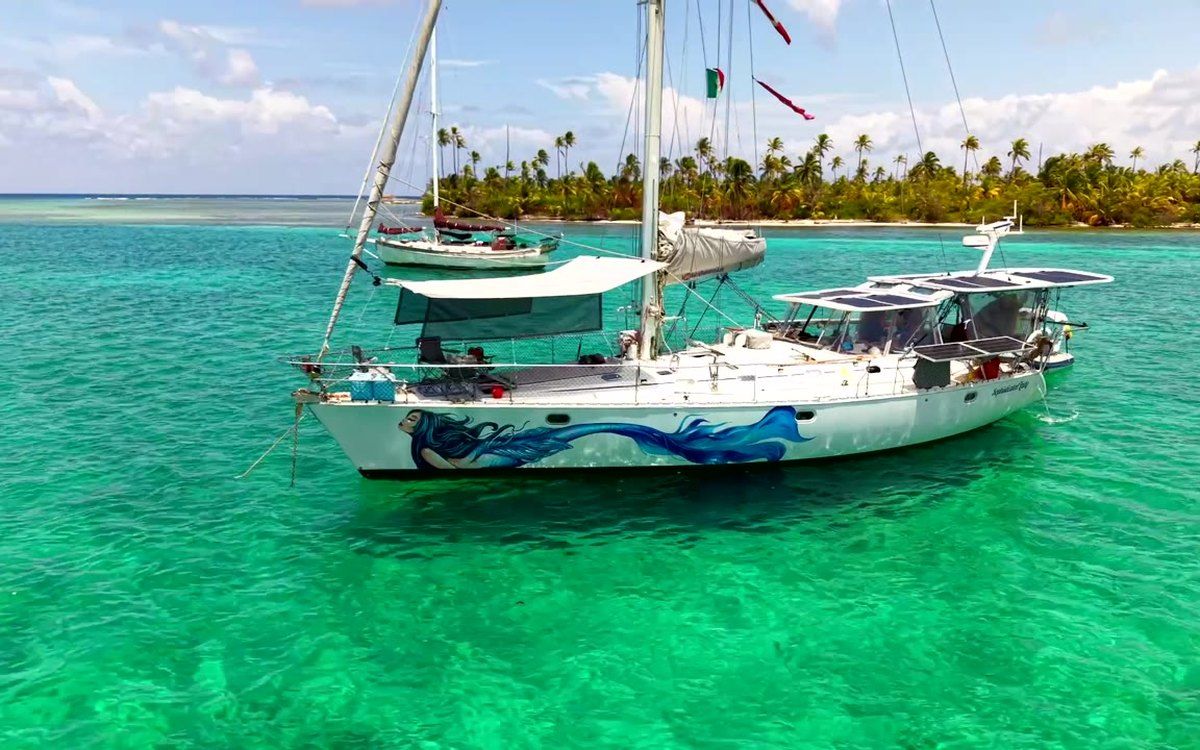 Sophisticated Lady at anchor on turquoise water off a palm-lined San Blas island