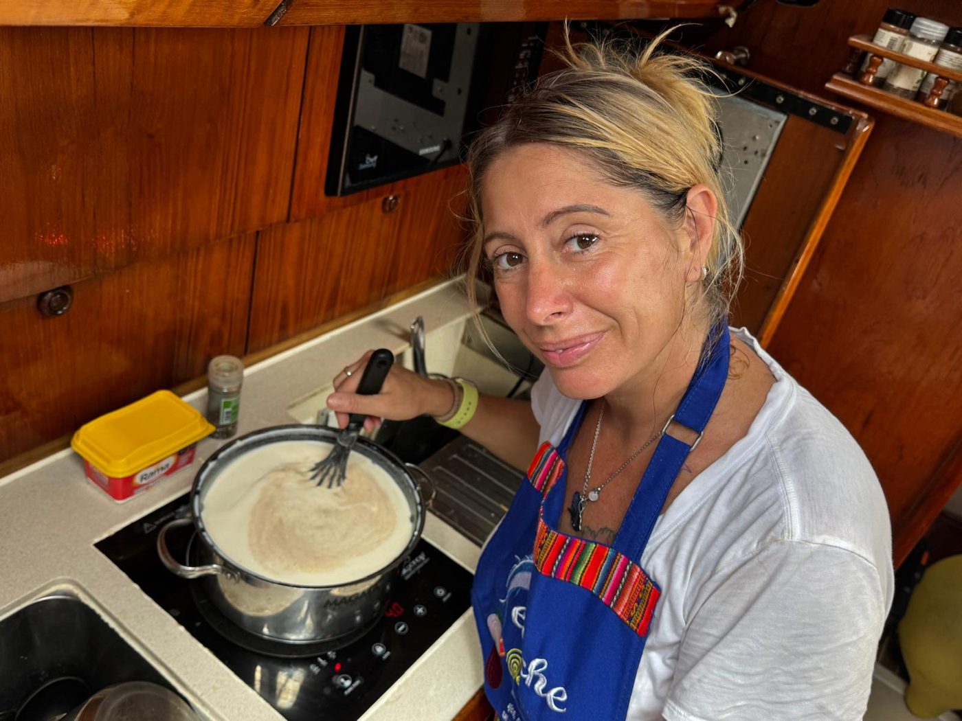 Maddy cooking at the stove in the galley