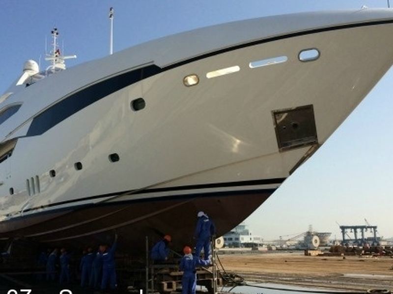 A large motor yacht hull in a boatyard